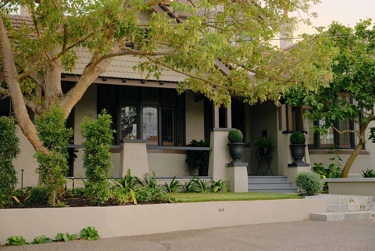 Balaclava — period house facade behind tree, black urns flanking entry steps