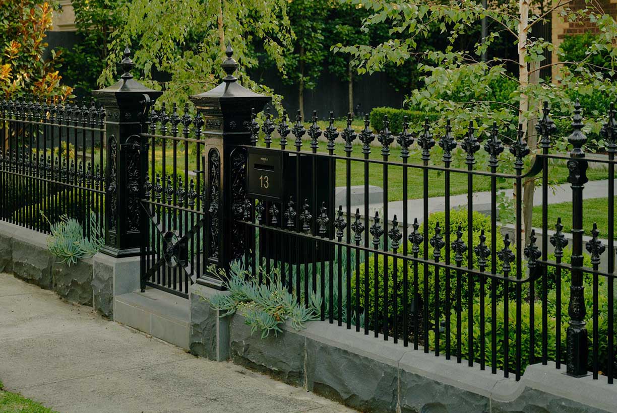Hampden — period house behind ornate black iron fence and gate, birch tree